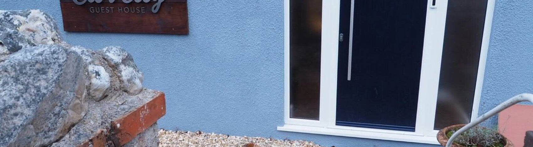 Cat sitting outside Clovelly Guest House door