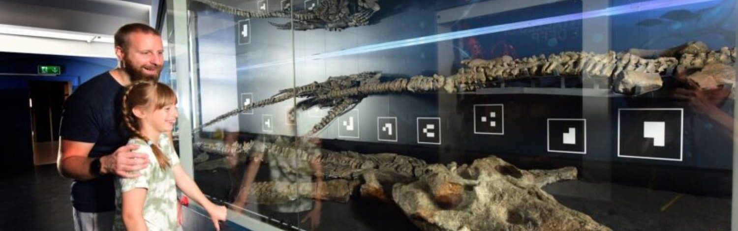 Father and daughter exploring dinosaur fossils