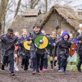 Kids in Viking attire running outside