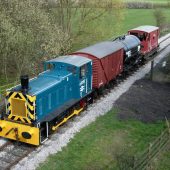 Blue train on rural track with cargo cars