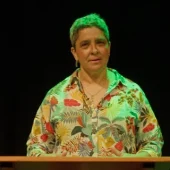 Person speaking at a podium under green light