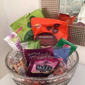 Bowl of assorted snack bags on table