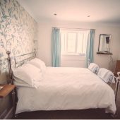 Cozy bedroom with floral wallpaper and TV
