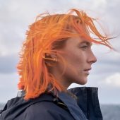 Orange-haired person by the sea