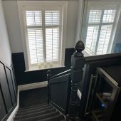 Dark carpeted staircase with window