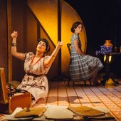Two women in vintage dresses on stage