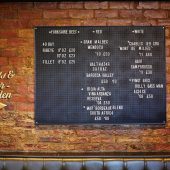 Pub menu on brick wall with beef and wines