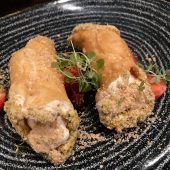Cannoli with cream filling and herbs on plate