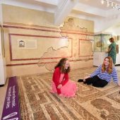 Museum exhibit with visitors and mosaic floor