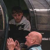 Man talking to a boy in a helicopter cockpit
